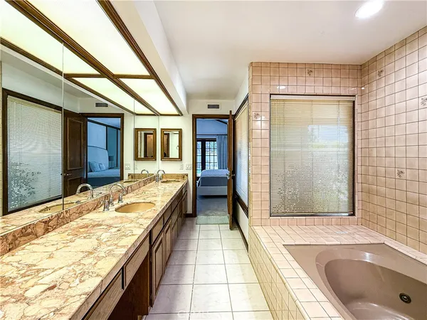 a bathroom with a tub sink and mirror