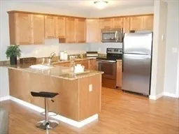 a kitchen with kitchen island a counter space a sink appliances and cabinets