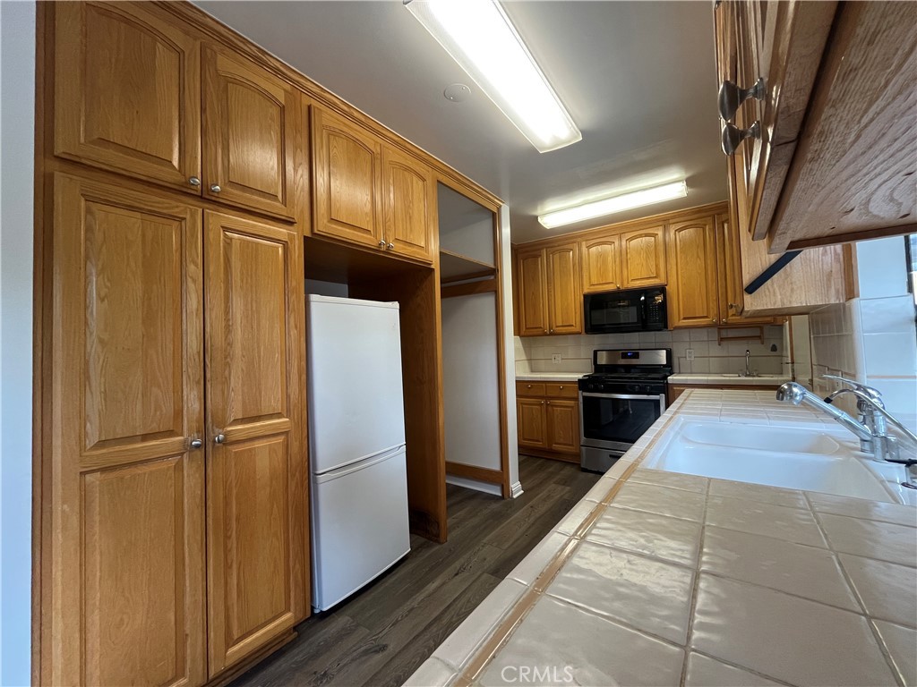18029 Santa Rita Street Encino, CA 91316 - Photo 5 of 20 a kitchen with stainless steel appliances granite countertop a refrigerator stove and sink
