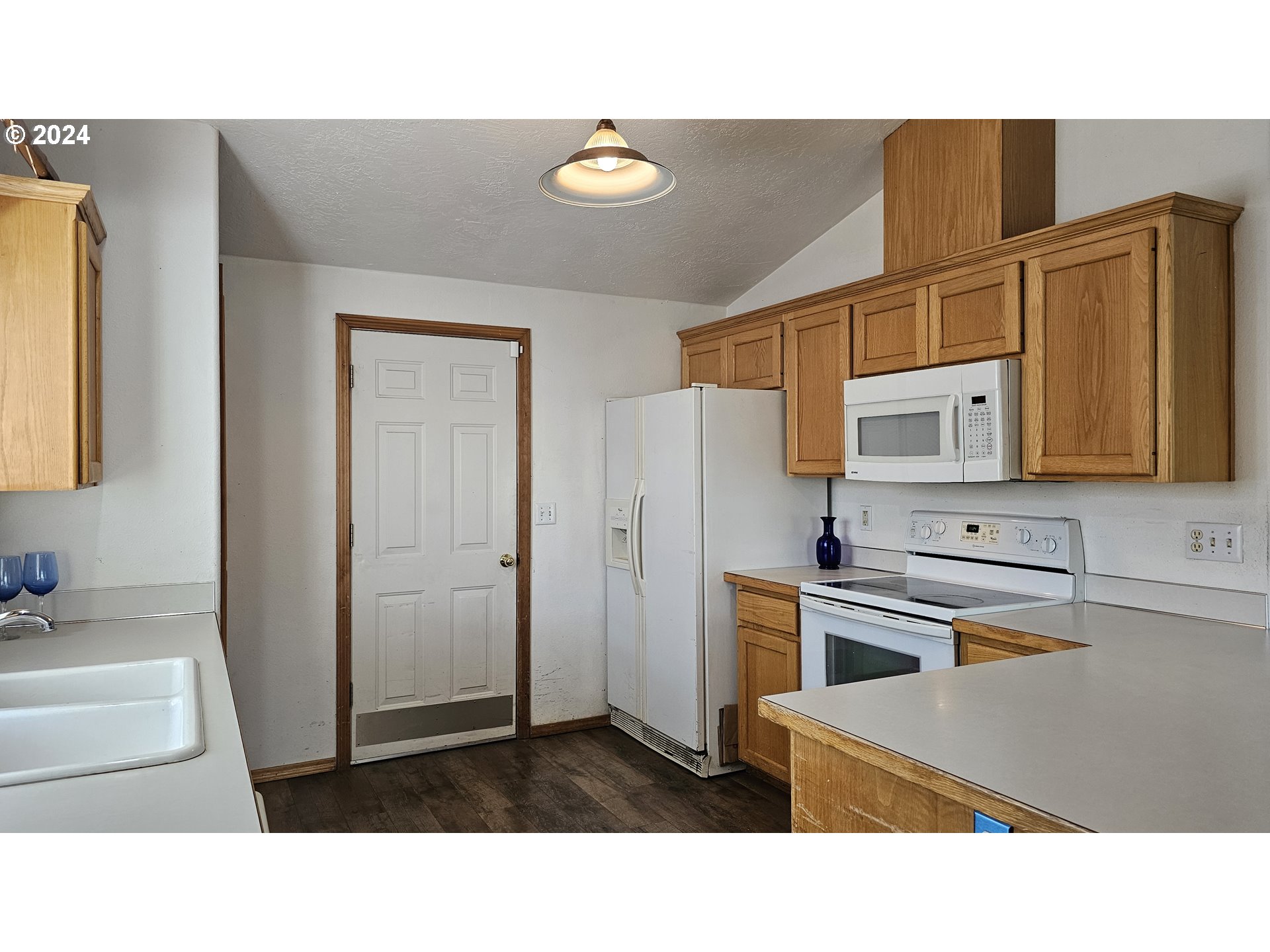 4072 Forsythia Street Springfield, OR 97478 - Photo 6 of 23 a kitchen with stainless steel appliances a refrigerator a sink and white cabinets