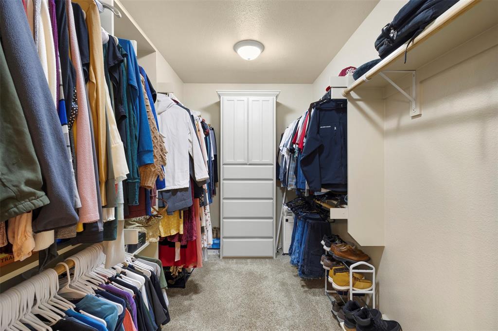105 Country Ridge Court Red Oak, TX 75154 - Photo 25 of 40 a view of walk in closet with clothes and shoes