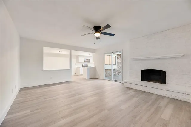 an empty room with windows and fireplace