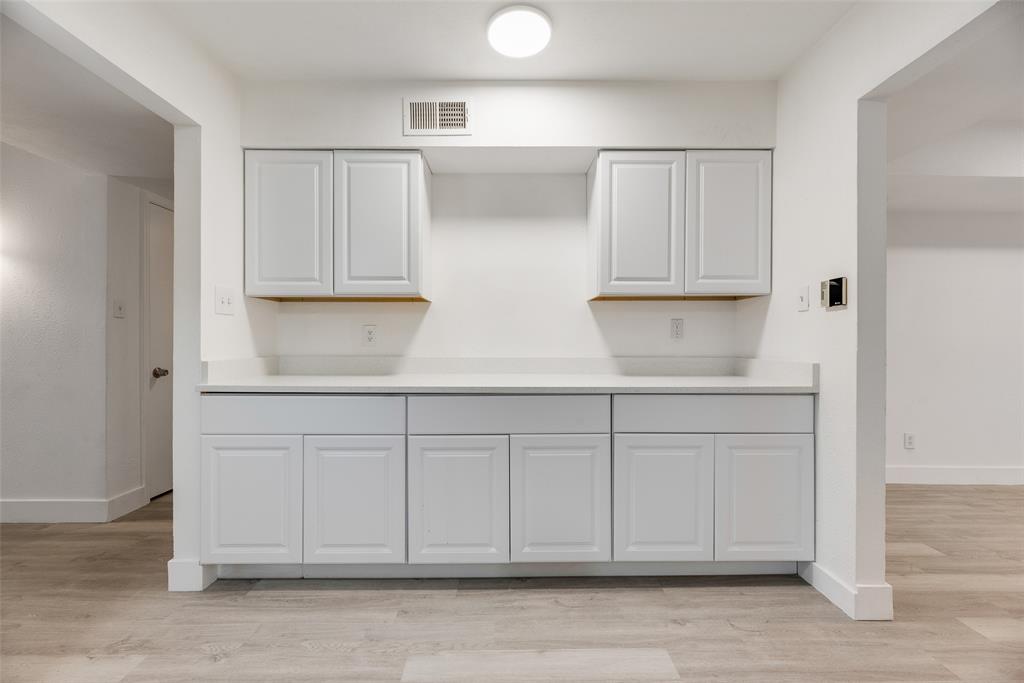 4512 Larner Street The Colony, TX 75056 - Photo 14 of 29 a kitchen with white cabinets