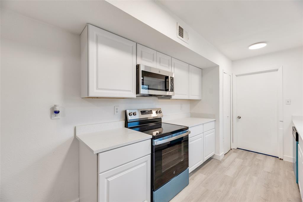 4512 Larner Street The Colony, TX 75056 - Photo 15 of 29 a kitchen with stainless steel appliances granite countertop white cabinets a stove top oven a sink and dishwasher
