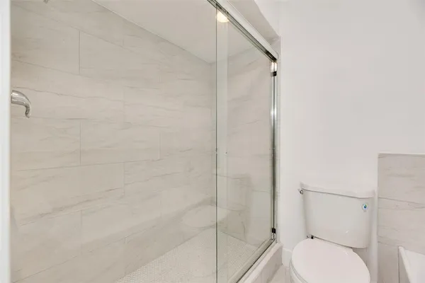 a bathroom with a toilet and a shower