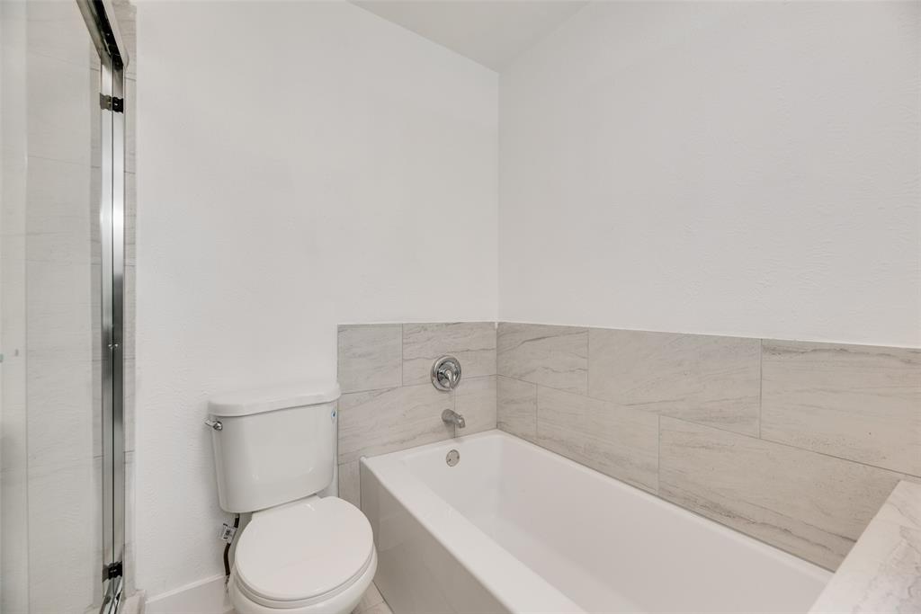 4512 Larner Street The Colony, TX 75056 - Photo 20 of 29 a bathroom with a toilet and bathtub