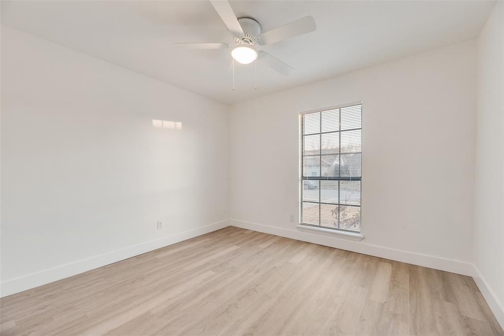 4512 Larner Street The Colony, TX 75056 - Photo 26 of 29 an empty room with wooden floor ceiling fan and windows