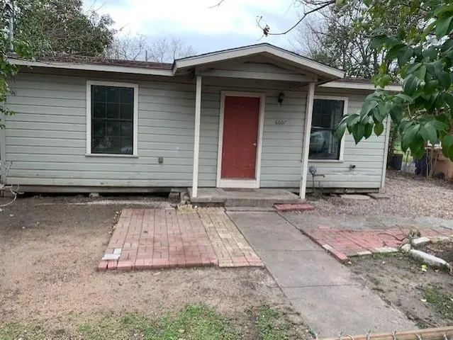 a small barn with a table and chairs in front of house