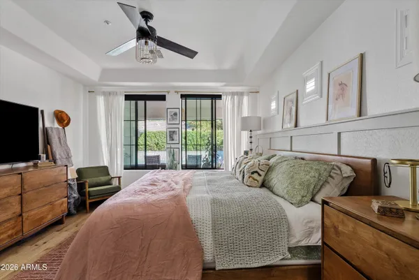 a bedroom with a bed a flat screen tv and a window