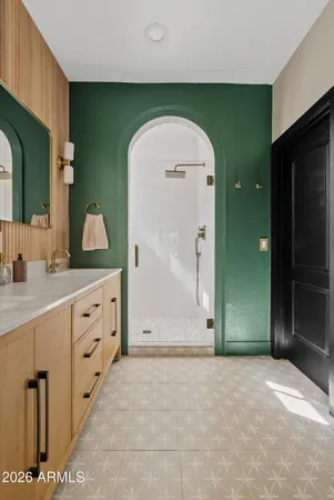 a spacious bathroom with a granite countertop sink a mirror and a shower