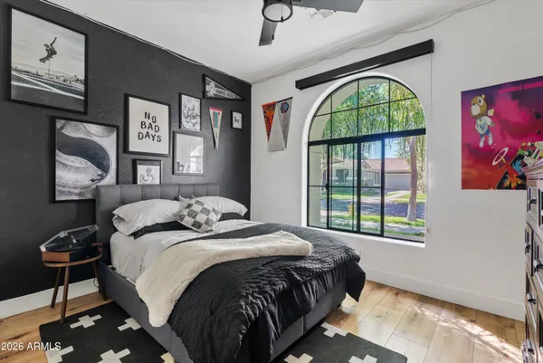 a bedroom with a bed a dresser next to a window