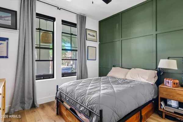 a bedroom with a bed and a flat tv screen on dresser