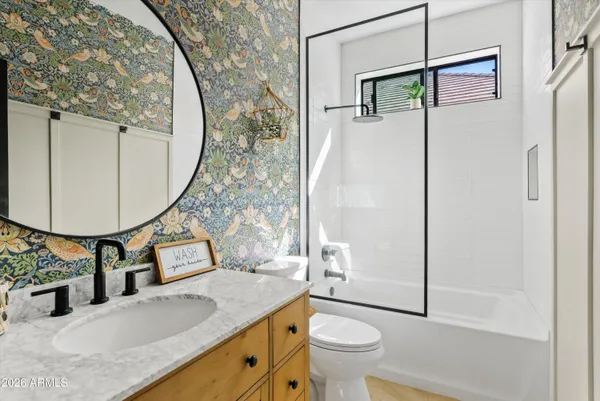 a bathroom with a granite countertop sink toilet and a mirror