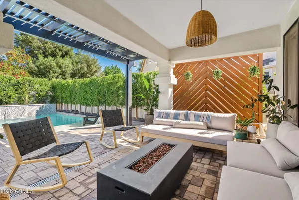 a living room with patio furniture and a potted plant