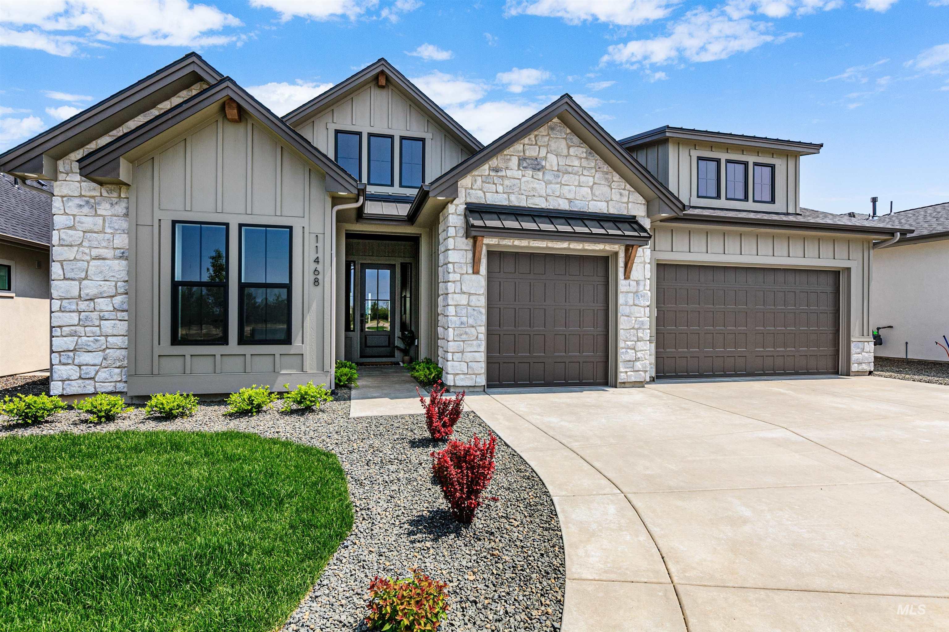 11468 South Saylis Place Kuna, ID 83634 - Photo 2 of 38 View of front of home featuring concrete driveway, board and batten siding, an attached garage, stone siding, and a front yard