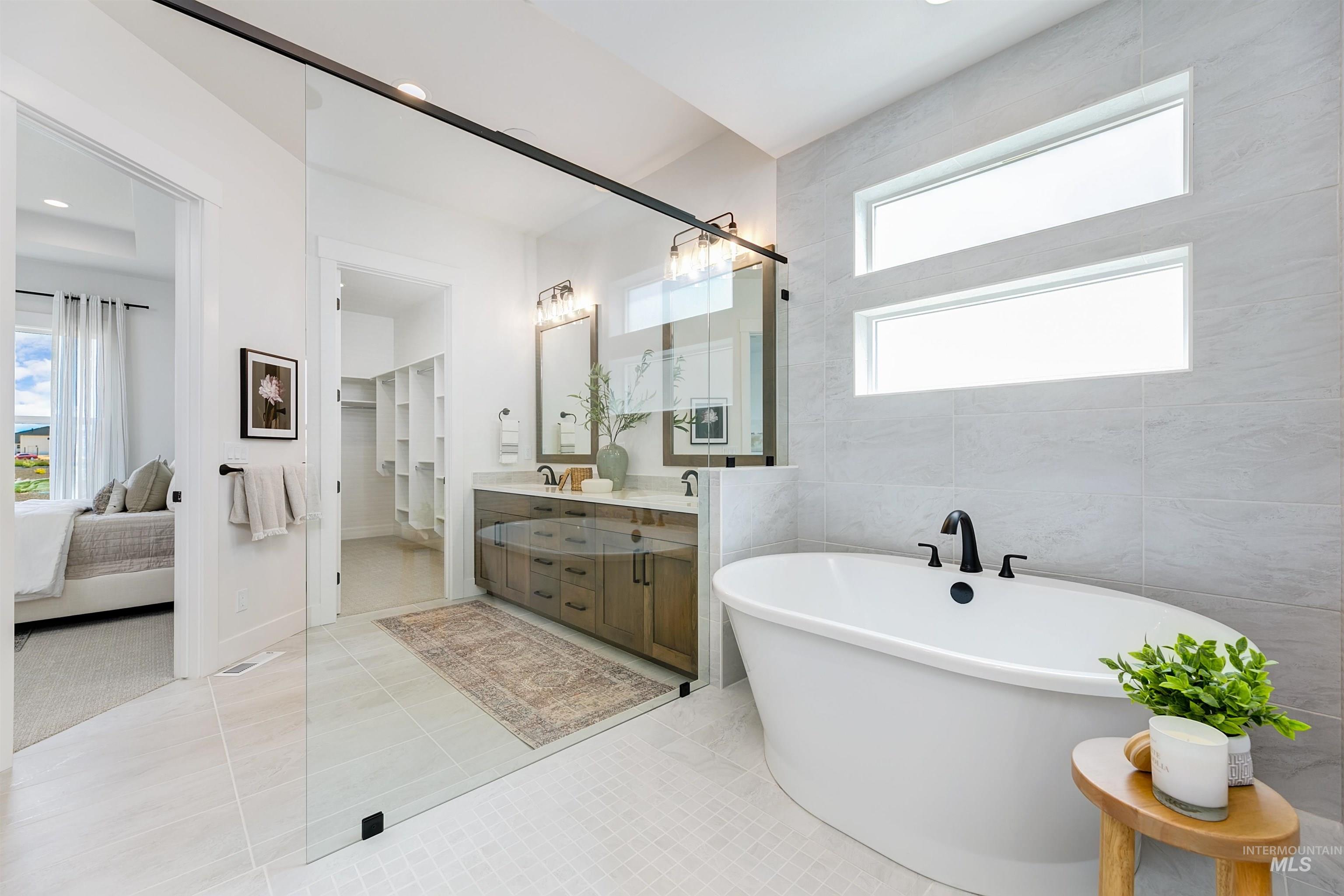 11468 South Saylis Place Kuna, ID 83634 - Photo 21 of 38 Ensuite bathroom with double vanity, light tile patterned floors, a soaking tub, and tile walls