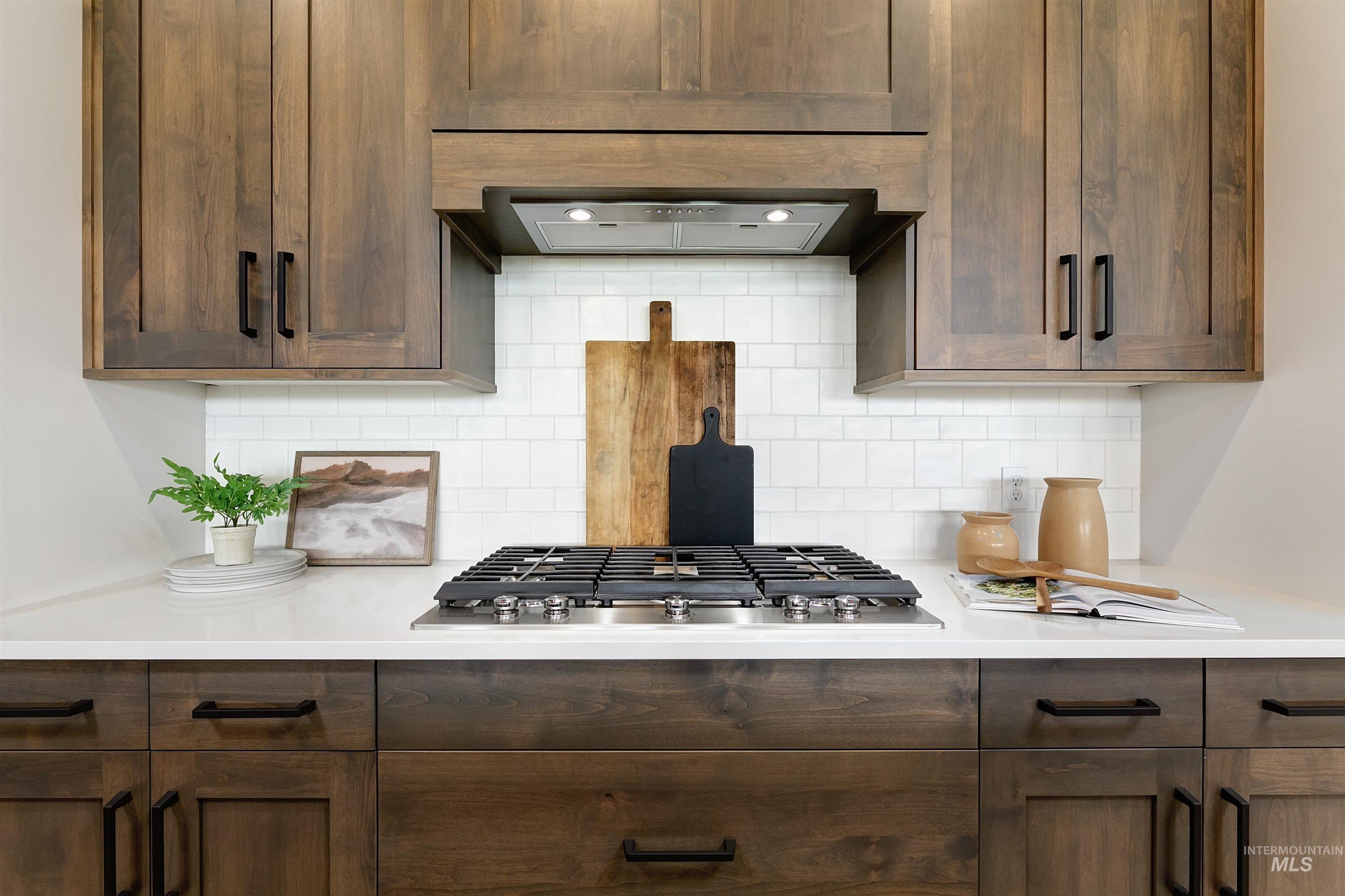 11468 South Saylis Place Kuna, ID 83634 - Photo 10 of 38 Kitchen featuring dark wood finish cabinets, stainless steel gas stovetop, and decorative backsplash