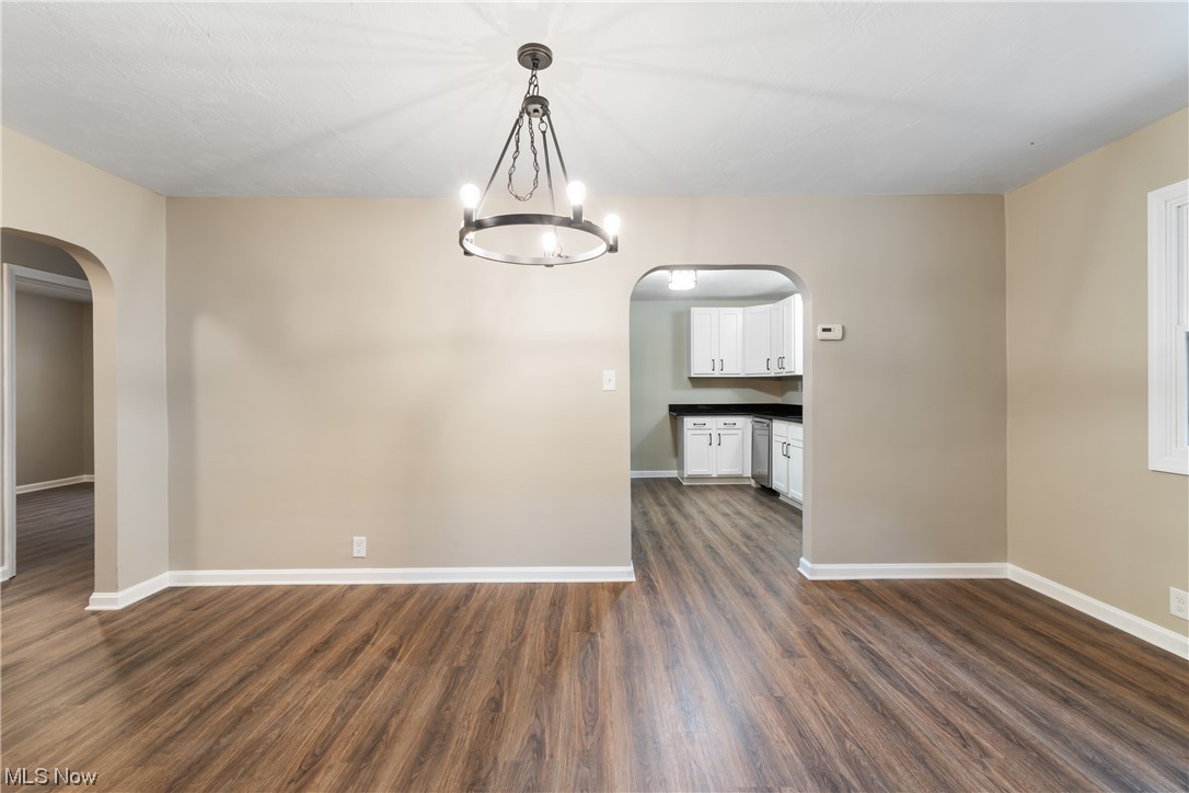 916 Renninger Road Akron, OH 44319 - Photo 16 of 31 Empty room with dark hardwood / wood-style flooring and a notable chandelier