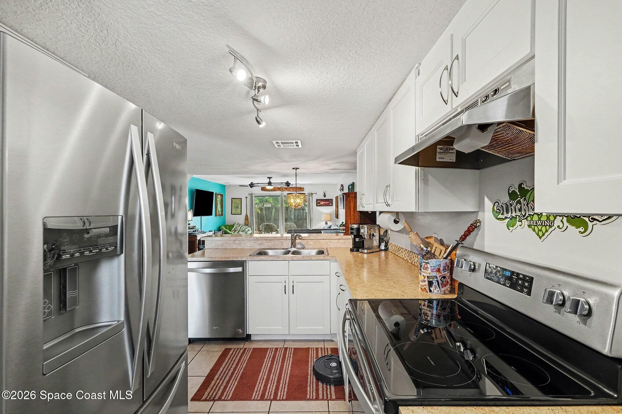 290 North 2nd Street, Unit 3 Cocoa Beach, FL 32931 - Photo 14 of 31 a kitchen with a stove and a refrigerator