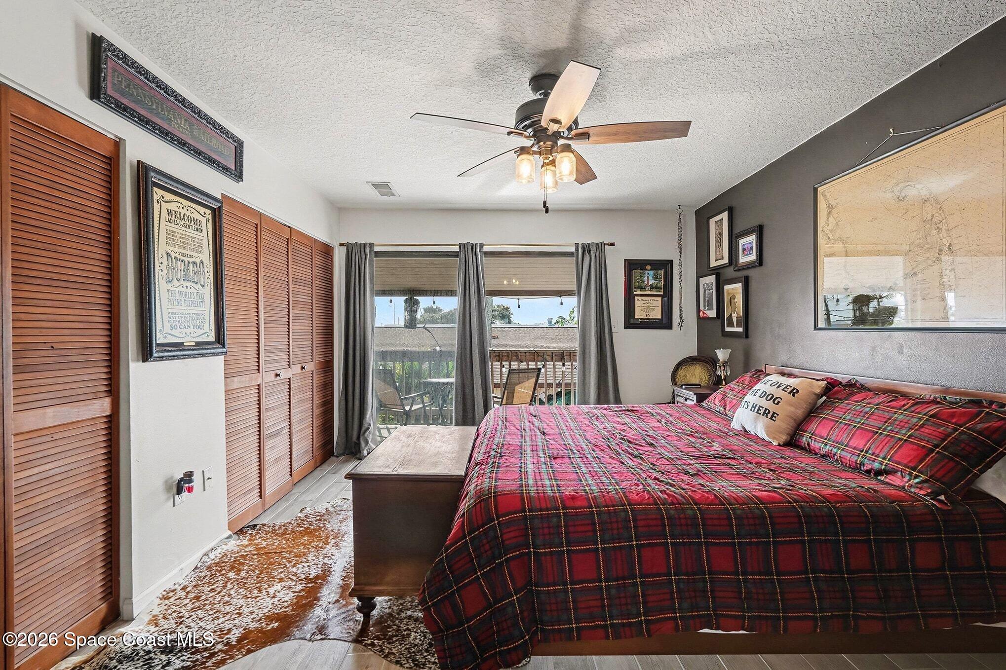 290 North 2nd Street, Unit 3 Cocoa Beach, FL 32931 - Photo 21 of 31 a bedroom with a large bed and a chandelier