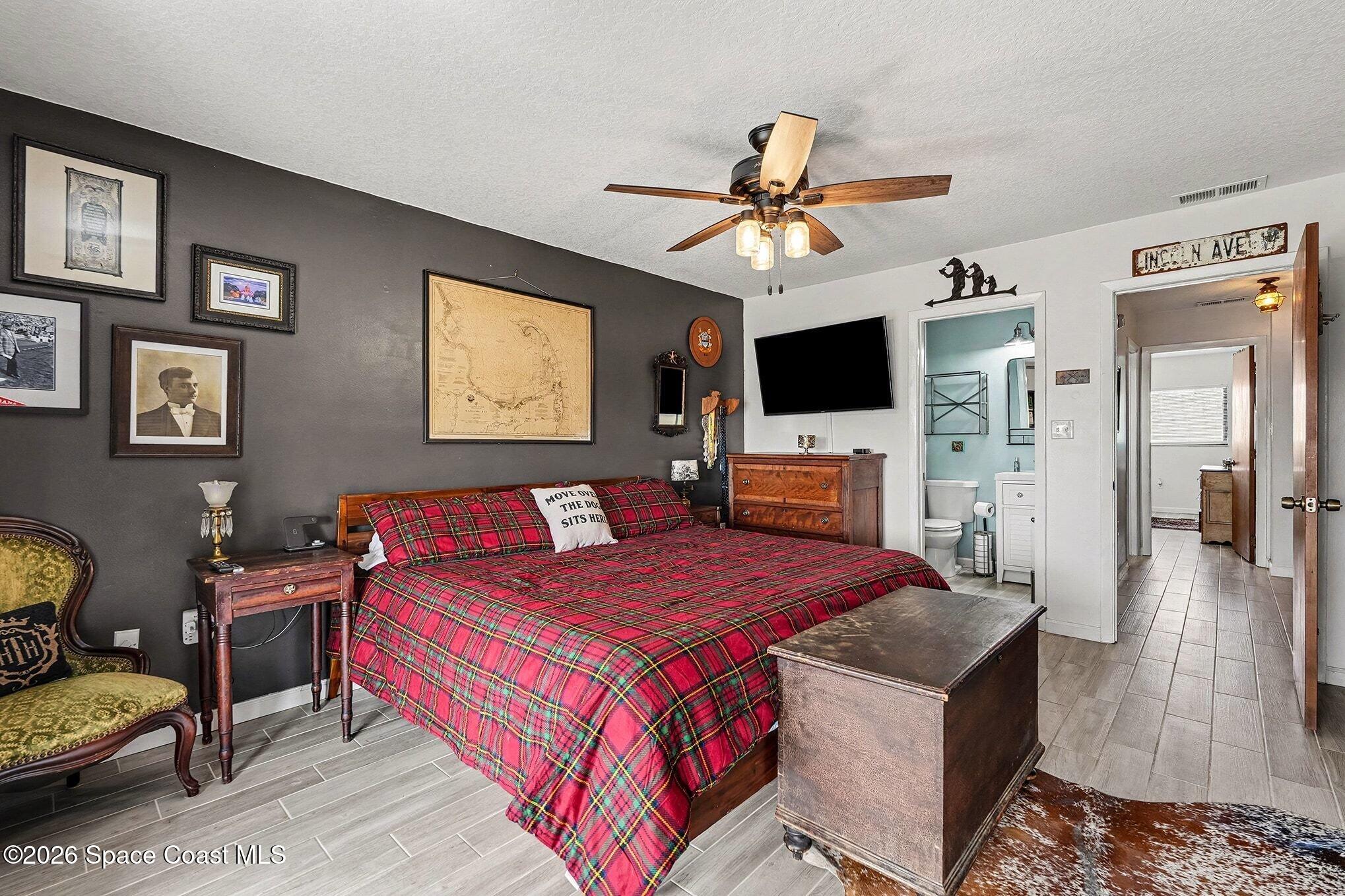 290 North 2nd Street, Unit 3 Cocoa Beach, FL 32931 - Photo 22 of 31 a bedroom with a bed a couch and a flat screen tv