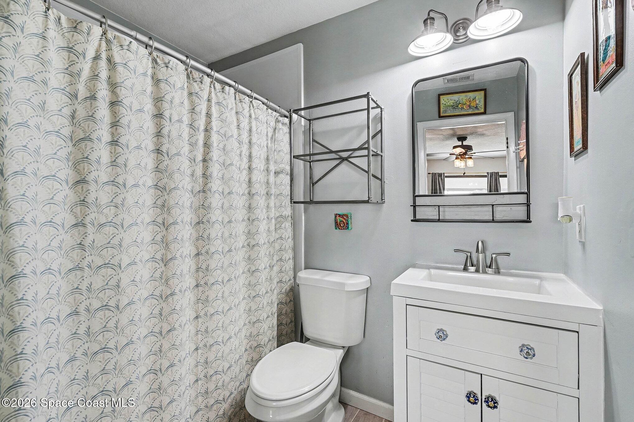 290 North 2nd Street, Unit 3 Cocoa Beach, FL 32931 - Photo 24 of 31 a bathroom with a sink vanity mirror and toilet