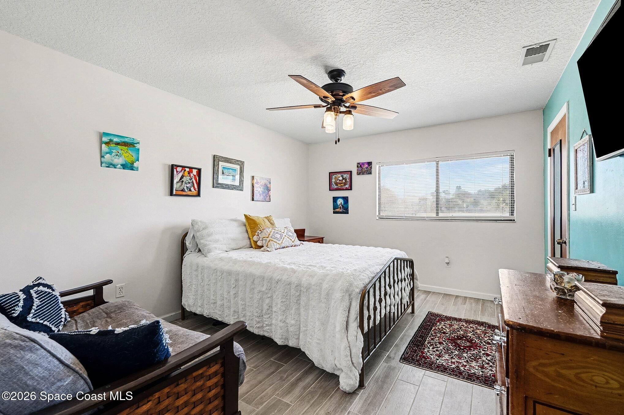 290 North 2nd Street, Unit 3 Cocoa Beach, FL 32931 - Photo 25 of 31 a bedroom with a bed and a flat screen tv