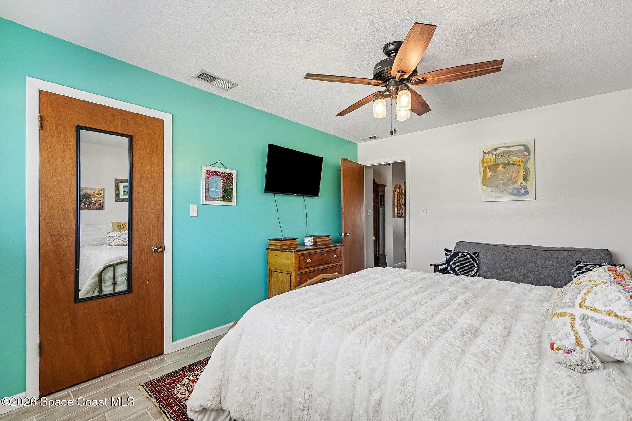 290 North 2nd Street, Unit 3 Cocoa Beach, FL 32931 - Photo 26 of 31 a bedroom with a bed and a chandelier