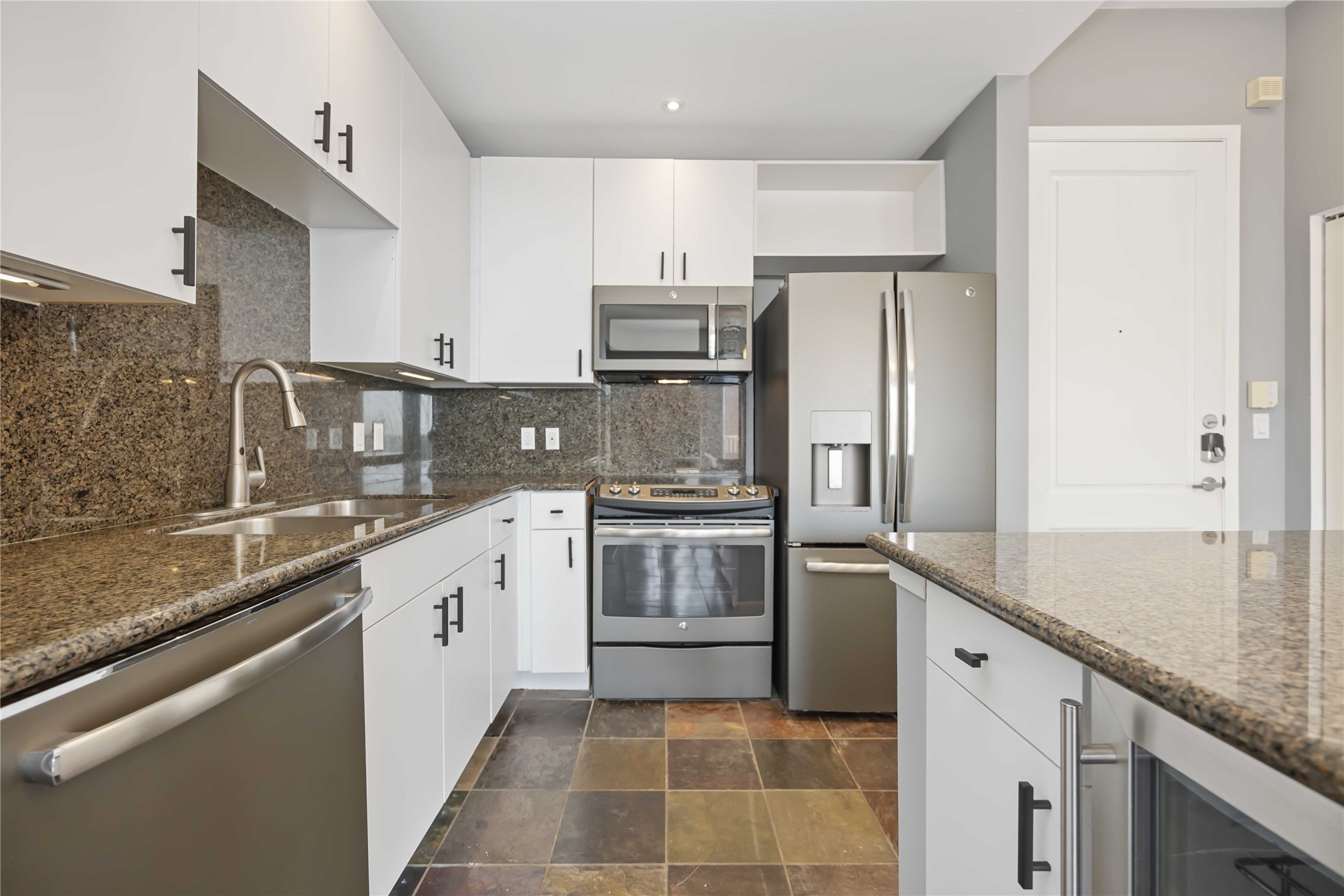 3505 Sage Road, Unit 1508 Houston, TX 77056 - Photo 3 of 23 The modern kitchen layout showcases updated white cabinetry, a built-in microwave, a dishwasher, and stainless steel appliances to ensure streamlined clean-up and meal prep.