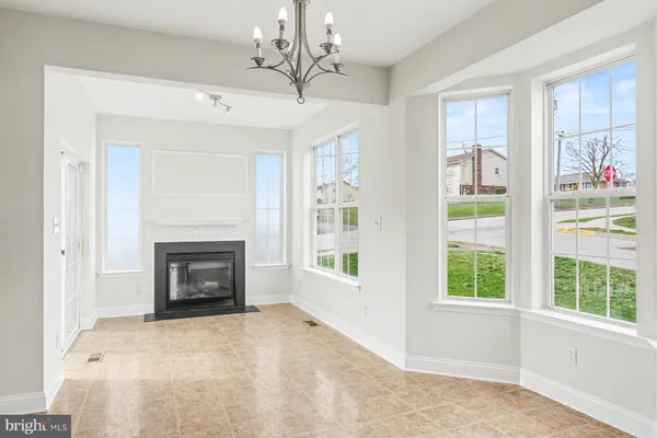a view of an empty room with a fireplace and a window