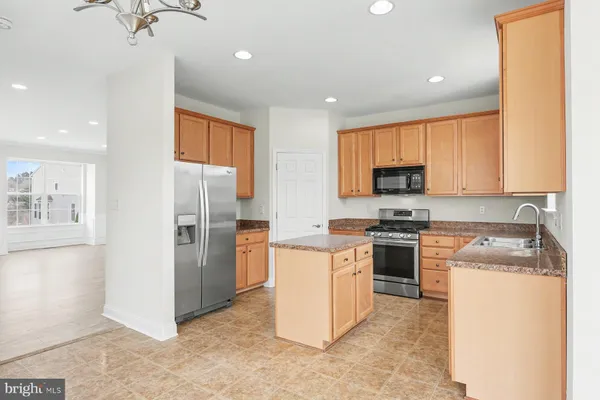 a kitchen with a refrigerator a stove top oven a sink dishwasher and white cabinets with wooden floor