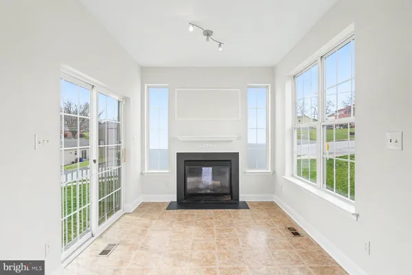 a view of an empty room with a window and a fireplace