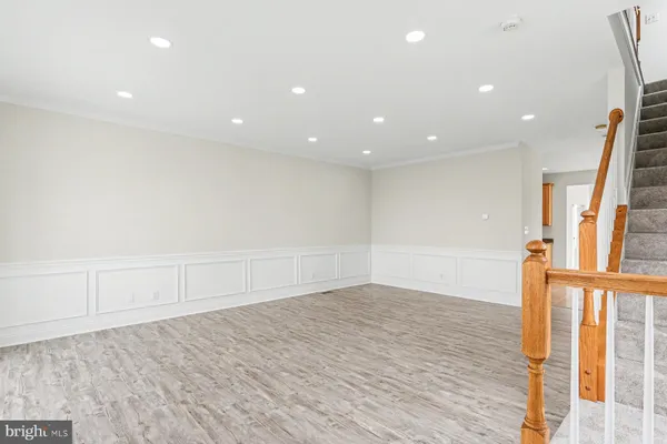 an empty room with wooden floor and entrance