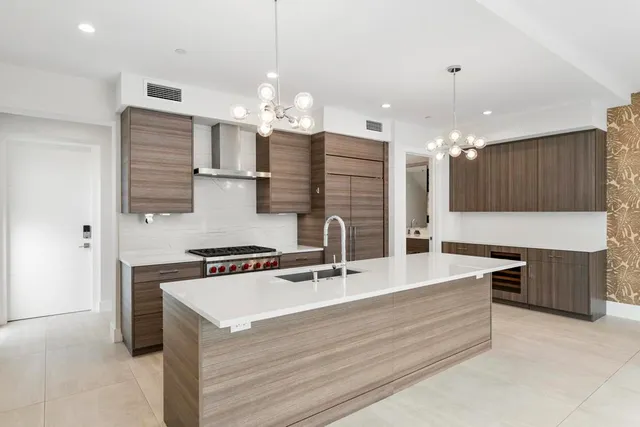 a kitchen with kitchen island a sink stainless steel appliances and a counter top space