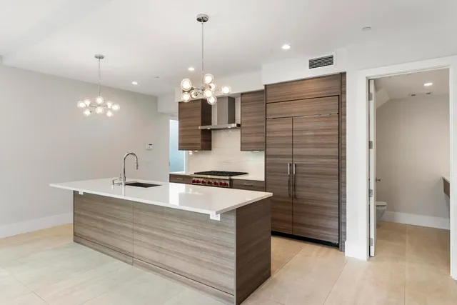 a large kitchen with a sink stainless steel appliances and cabinets