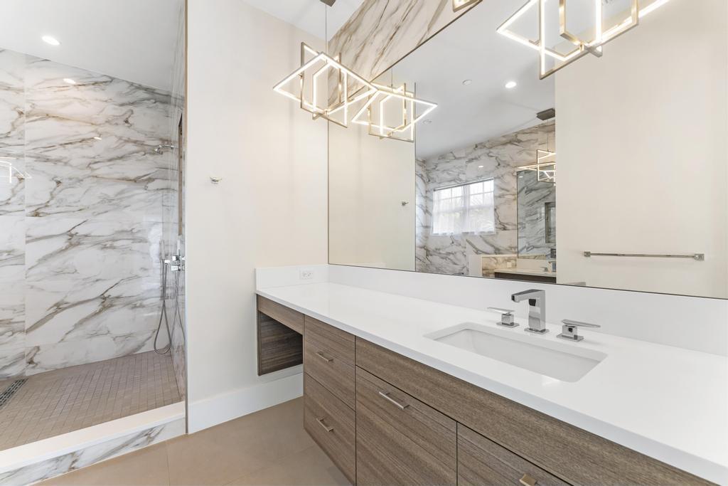 53 Southeast Seminole Street, Unit A Stuart, FL 34994 - Photo 37 of 75 a bathroom with a sink a mirror and a shower