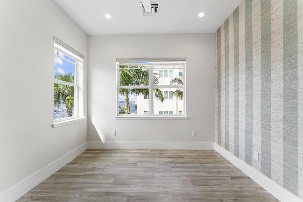 53 Southeast Seminole Street, Unit A Stuart, FL 34994 - Photo 49 of 75 a view of an empty room with wooden floor and a window