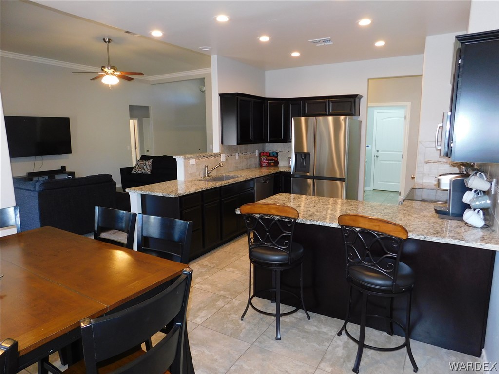 3370 South Ridge Avenue Bullhead City, AZ 86429 - Photo 30 of 56 a kitchen with a table chairs refrigerator and microwave