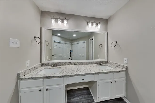 a bathroom with a granite countertop sink and a mirror