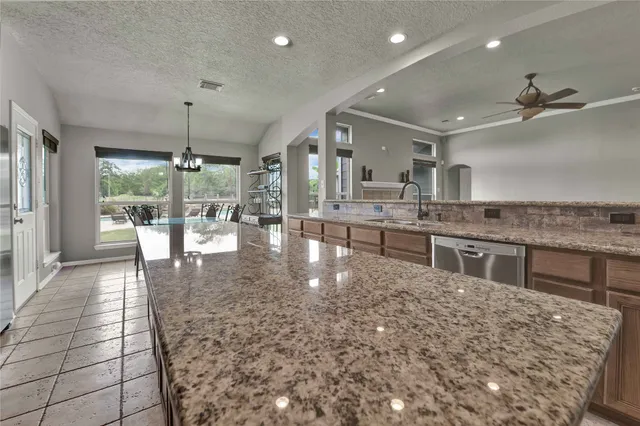 a kitchen with stainless steel appliances granite countertop a refrigerator a stove and a sink