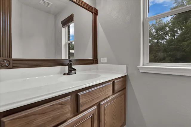 a bedroom with a bed next to a window and a chandelier