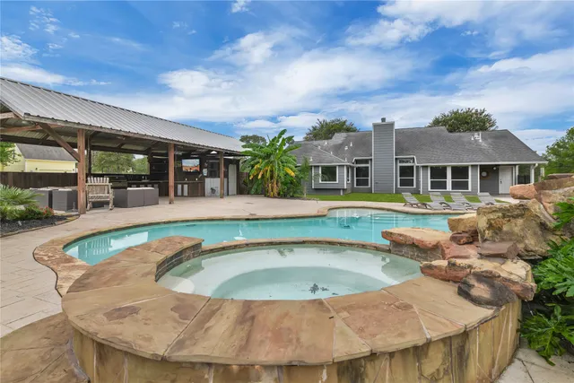 a view of a patio with table and chairs a barbeque with wooden fence and roof