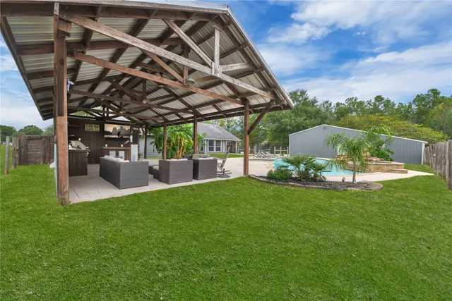 a view of a house with a yard patio and swimming pool