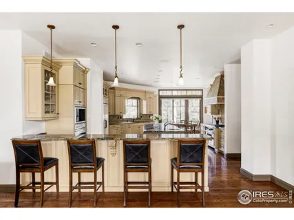 a dining hall with stainless steel appliances kitchen island granite countertop furniture and a view of living room
