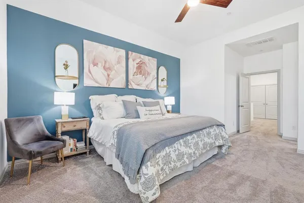 a spacious bedroom with a bed and chair