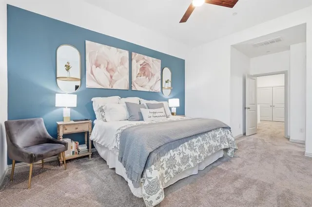 a spacious bedroom with a bed and chair