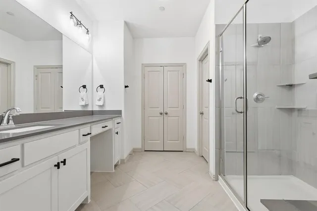 a spacious bathroom with a granite countertop sink mirror and shower