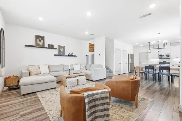 a living room with furniture and a wooden floor