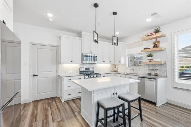 a kitchen with white cabinets and white appliances