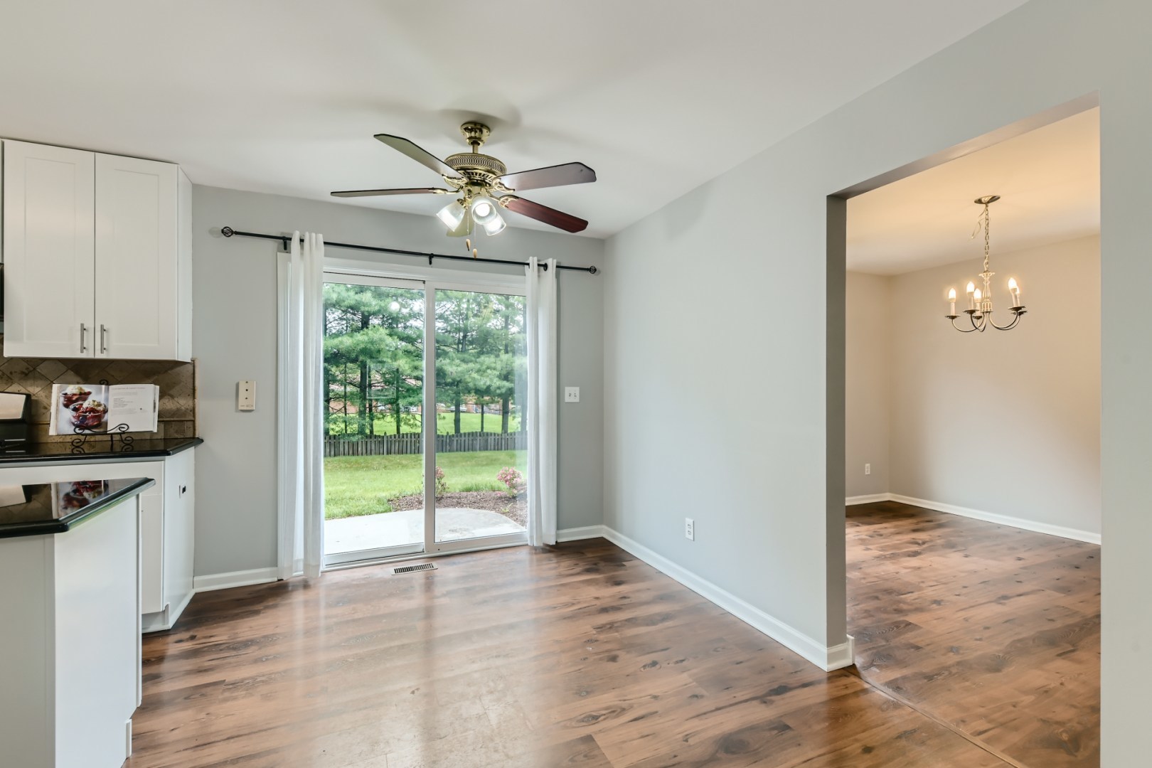 512 Susan Street Romeoville, IL 60446 - Photo 6 of 21 a view of a kitchen with wooden floor a ceiling fan and a kitchen view